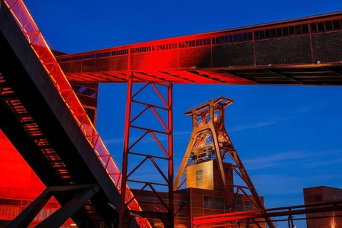 UNESCO World Heritage Zollverein Coal Mine Industrial Complex illuminated in red in the evening,