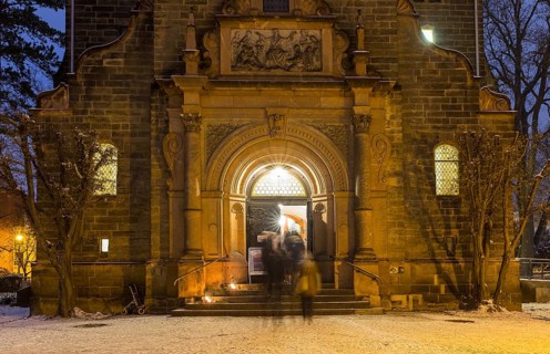 Church portal to the New Church of St Peter and Paul, churchgoers streaming into the church,