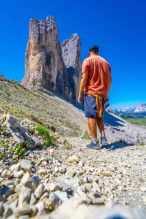 Hiker enjoying the breathtaking view of the tre cime di lavaredo peaks in the italian dolomites on