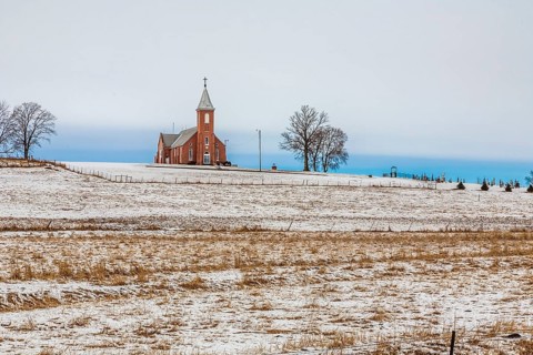Church and cemetery on a hill surrounded by grain fields in rural north east Nebraska, USA