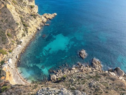 Aerial view of the stunning Costa Blanca coastline, capturing the rich blue waters of the