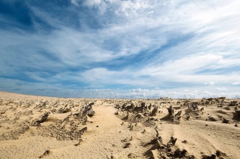 Natural sand formations in nature park dunes Corralejo, above blue sky with cirrus veil clouds,