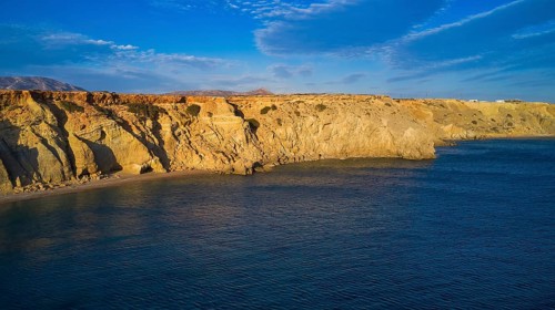 View of the wide sea with rocky coast and blue sky, drone shot, evening light, Paralia Agios