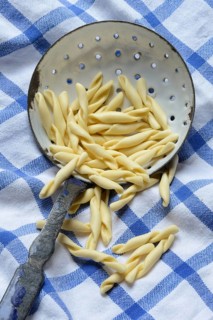 Strozzapreti, uncooked Italian pasta in a sieve, Italy