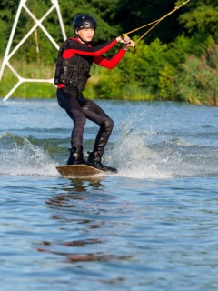 Young man doing sports with wakeboard in lake, water sports, water skiing in wakepark, Stráž pod