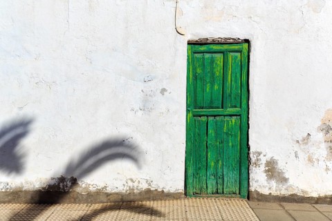 Green painted wooden door, white facade, peeling paint, facade detail, Haria, Lanzarote, Canary
