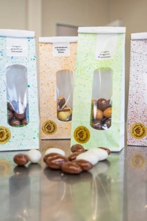Four different bags of handmade chocolate chocolates arranged on a table, Easter production of