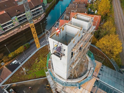 Construction of a tower in an urban environment with workers and crane, ZOB Calw reconstruction for