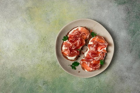 Sandwich with cream cheese and prosciutto, on black grain bread, breakfast, homemade