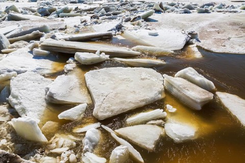 Close-up of large blocks of thick jagged ice floes floating on the surface of the Mille-Iles river