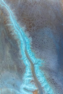 A mesmerizing aerial view of an abstract cracked landscape pattern, featuring intricate blue and