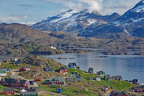 A colorful village with snow-capped mountains and calm water, Tasilaq, Arctic, Greenland, Denmark