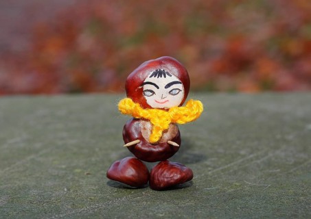 Funny chestnut figure with yellow scarf on a wall, North Rhine-Westphalia, Germany