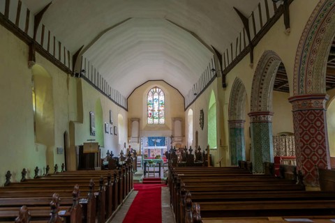 Nave to altar and east window inside church of Saint Peter, Theberton, Suffolk, England, UK