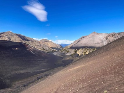 The lava scree slopes of the Achen Niyue volcano with a woman climbing up, Lanin National Park,