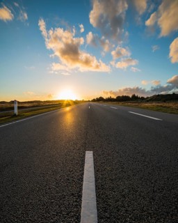 Sunrise over country road with central reservation, Jutland, Denmark