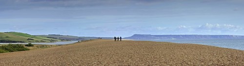 Fleet Lagoon at Abbotsbury and tourists walking on Chesil Beach tombolo, one of three major shingle