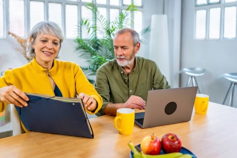 Senior couple using laptop while planning their home budget together at home
