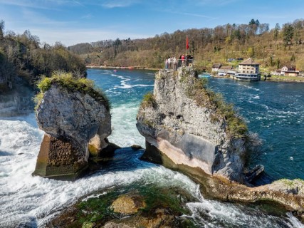 Aerial view of the Rhine Falls at low water in spring, with tourists on the viewing platform, on