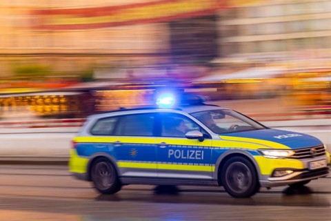 A police car on an emergency drive on Wilsdruffer Straße at Altmarkt with flashing blue lights,