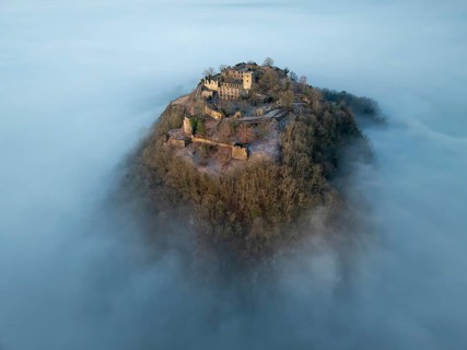 Aerial view of the Hegau volcano Hohentwiel with the upper fortress ruins in front of sunrise,