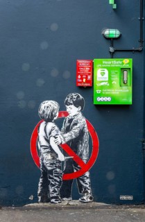 Mural street art two young boys one with knife Anti knife piece 2020 by JPS artist Jamie Scanlon,