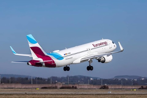 Stuttgart airport with plane taking off. Registration: D-AEWS, Eurowings, Airbus A320-200.