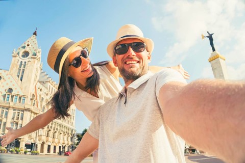 Happy young couple taking selfie in front Batumi europe square traditional city buildings. Two