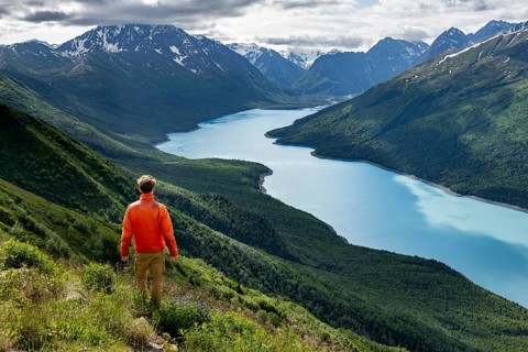 Mountaineer enjoys views of blue lake and mountains on Twin Peaks Trail, Eklutna Lake, Chugach