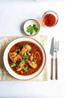 Traditional Georgian chakhokhbili features tender chicken cooked in a flavorful tomato sauce with