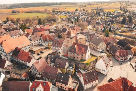 Aerial view of a village with a church and many half-timbered houses in a rural area, Ötisheim,