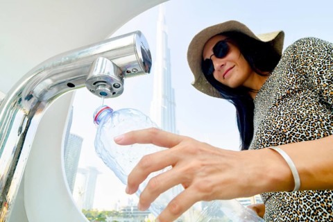 Dubai, UAE - 12th october, 2022: tourist woman use water refill machines in public places for