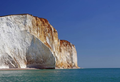High white cliffs towering over the calm blue water, Beachy Head Cliffs, English Channel,