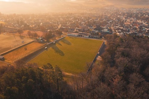 Aerial view of a soccer field and a settlement in a hilly landscape, Gechingen, Calw district,