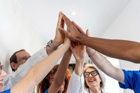Healthcare professionals from various backgrounds are celebrating success and teamwork,