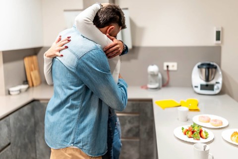 Romantic couple embracing in a cozy kitchen, enjoying a loving breakfast filled with pastries and