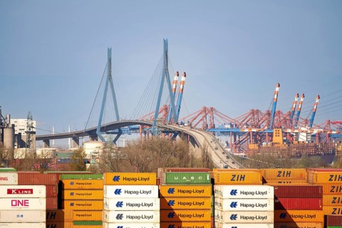 Köhlbrand bridge with Hapag-Lloyd harbour containers and blue sky in the background, Hamburg,