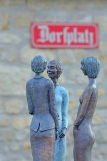 Sculpture Dorfgeflüster by Rosi Röhm 2021, bronze sculpture, three slender female figures in rural