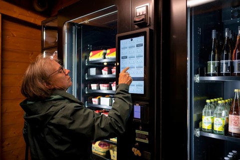 Elderly woman buying groceries at vending machine, display, food vending machine, farm shop,
