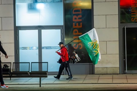 A supporter of the radical Free Saxons, walks with a Saxon flag and drum on Wilsdruffer Straße for
