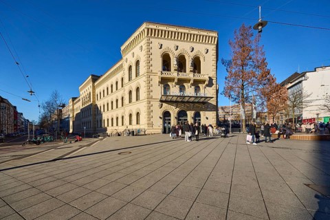 Pedestrian zone, footpath made of paving slabs, shopping centre, trees, pedestrians as accessories,