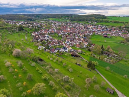 Idyllic landscape with a village and orchards under a partly cloudy sky, Ostelsheim, district of