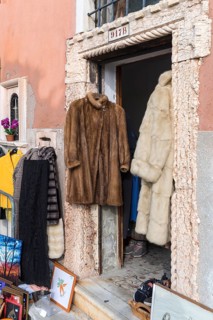 Fur coats hanging in a door for sale, Venice, Veneto, Italy