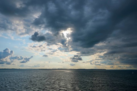 Dramatically cloudy sky over the Baltic Sea, broken by rays of sunshine, autumn, Kiel,