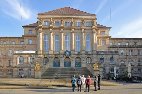 Town hall built in 1909 with open staircase and two golden lion figures and group of people,