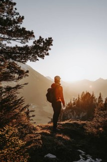Hiker in the Allgäu at sunset in spring on the Zirmgrat near Pronten in the Allgäu
