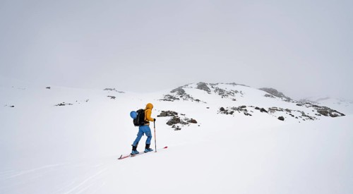 Ski tourers in a wintry mountain landscape with cloudy mountain peaks, ascent to Piz Laviner,