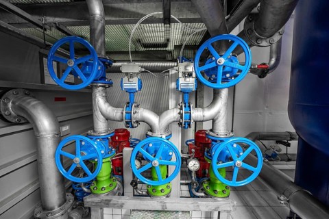 Complex arrangement of colourful valves and pipes in a technical room, ENCW Netze Calw waterworks,