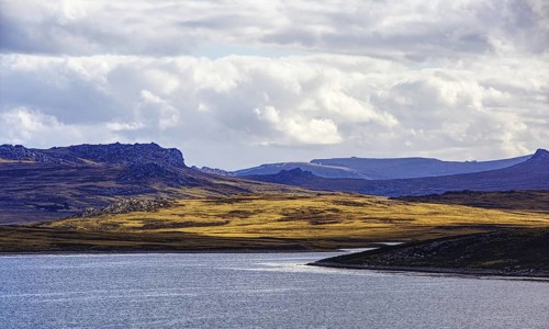 Playing light over mountains and water with dramatic clouds in the background, Stanley, East