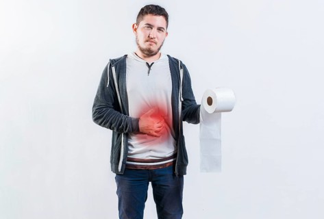 Person with diarrhea and stomach problems holding toilet paper. Man suffering with stomach pain